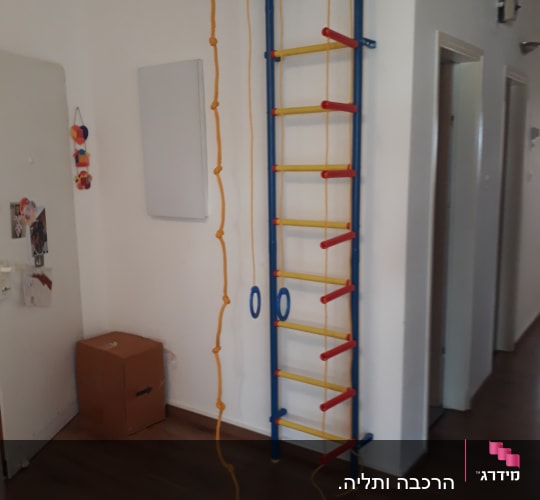 סולם טיפוס צבעוני עם חבלים על קיר